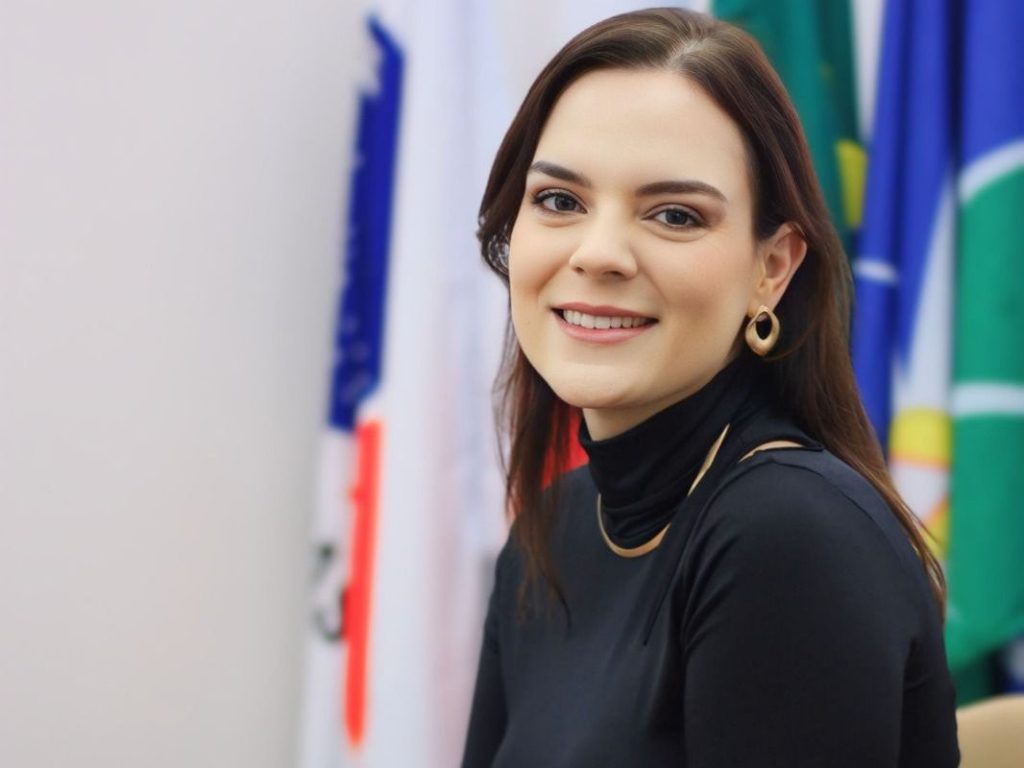 A jovem mulher sorrindo de forma amigável e confiante no ambiente trabalhista. Diferentemente das mediações em serviço, a ...